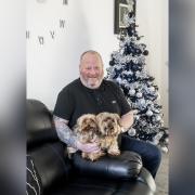 Army veteran Bobby Jones in his new Irvine home, all decorated for Christmas, alongside his two Yorkshire terriers.