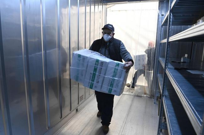 An employee unloads the newly arrived coronavirus vaccines from Chinese pharmaceutical company Sinopharm at the logistics base set up to in the car park of the government office in the 13th district of Budapest, Hungary (Noemi Bruzak/AP)