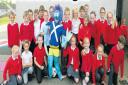 Annick Primary pupils show off one of their Hallowe'en scarecrows from 2013