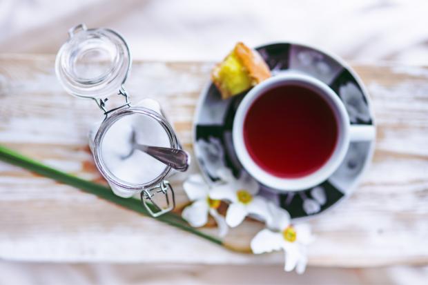 Irvine Times: A tea cup with cake on the saucer and an open sugar jar. Credit: Canva