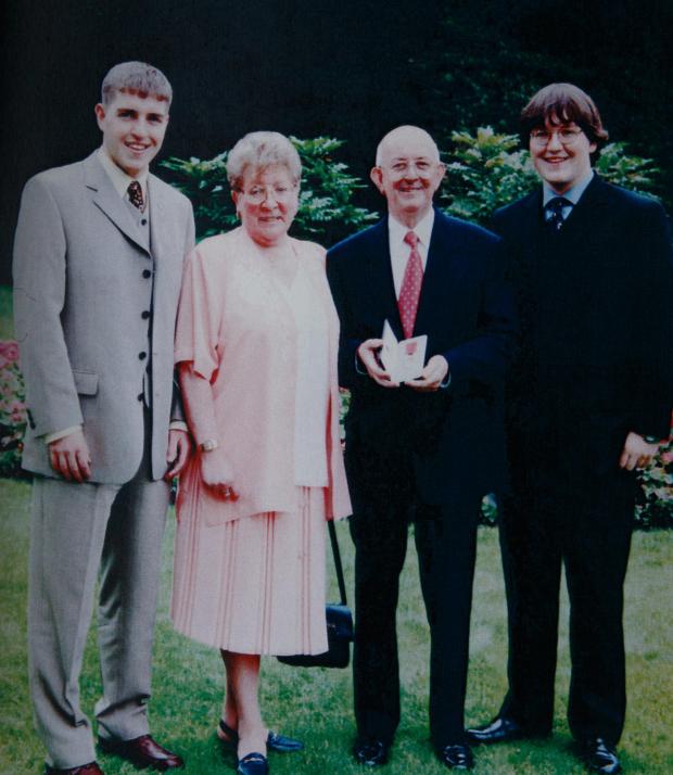 Irvine Times: Bobby Dinnie pictured (with his MBE) with his wife Betty and sons Robert, left and Russell on the right. Bobby, a Korean war veteran,  now age 89, is a retired football scout, was involved with the Possil YM football team for over 60 years and was
