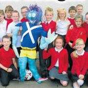 Annick Primary pupils show off one of their Hallowe'en scarecrows from 2013